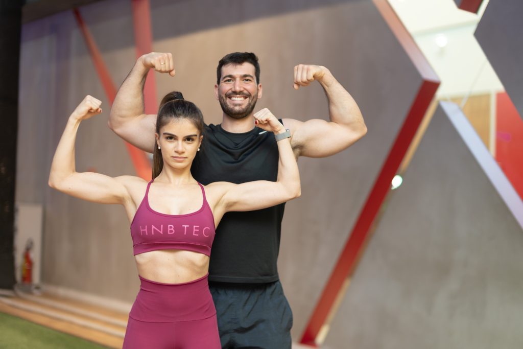 Casal mostra seus músculos revelando ter obtido a melhor divisão de treino para hipertrofia