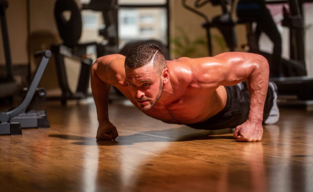 um atleta realizando flexões de braço, um exercício clássico de calistenia.