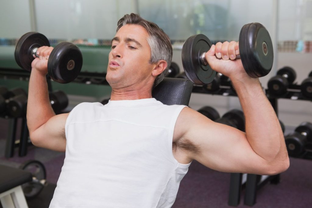 Homem fazendo desenvolvimento com halter.