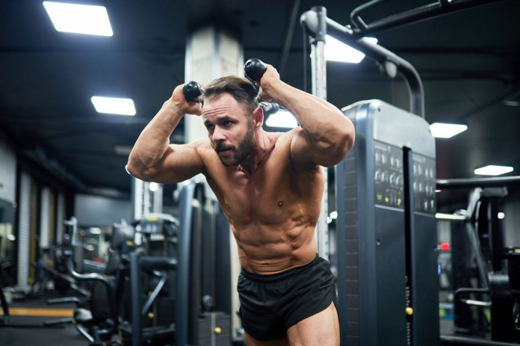 Homem fazendo exercício de musculação, tema ligado à pergunta para que serve whey protein.