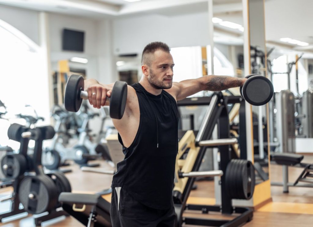 Homem fazendo elevação lateral como exercícios para ombro.